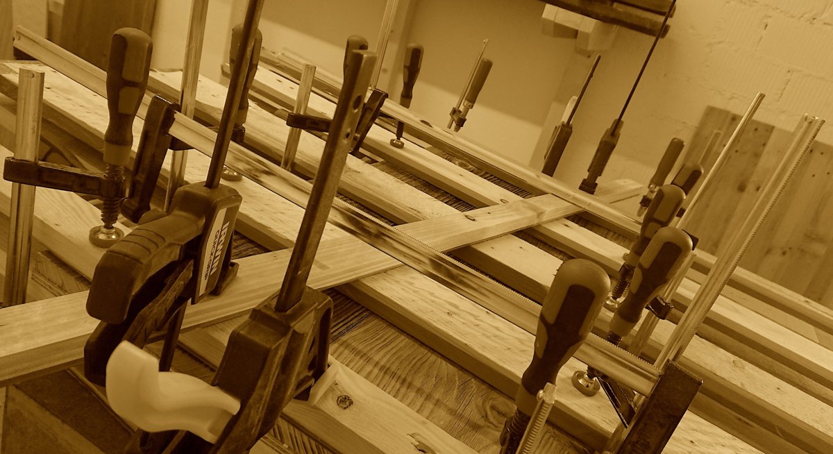 Reclaimed pine boards glued up under clamps